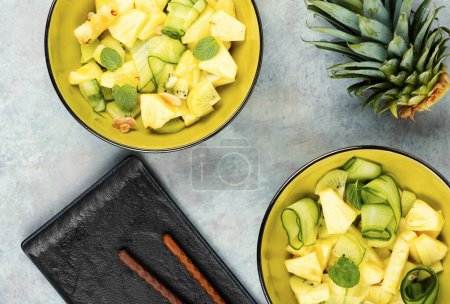 Téléchargez les photos : Salade végétarienne saine avec ananas ou ananas, noix et concombre dans un bol. Vue du dessus. - en image libre de droit