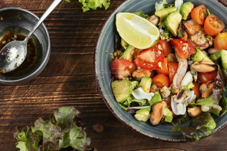 Téléchargez les photos : Délicieuse salade fraîche de légumes et fruits de mer. Salade italienne de fruits de mer sur une vieille table en bois. - en image libre de droit