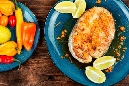 Photo for Roasted salmon or trout steak with orange and lime sauce on wooden table. - Royalty Free Image