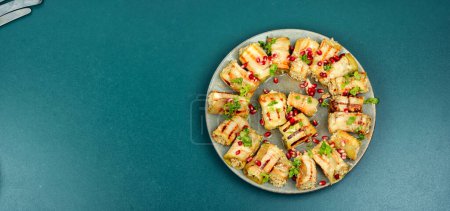 Photo for Badrijani, a famous Georgian dish, is a snack made from eggplant, meat and nuts. Healthy food. Space for text. - Royalty Free Image