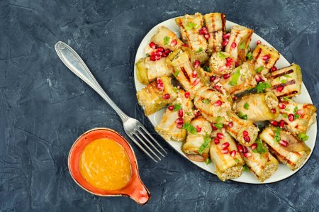 Téléchargez les photos : Rouleaux d'aubergine frits avec noix, garniture à l'ail et décorés de grenade. Badrijani - en image libre de droit