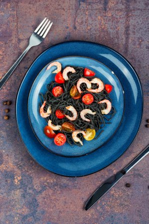 Vegan black bean spaghetti with shrimp and tomatoes.
