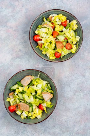 Photo for Tasty salad with cabbage, lettuce, cucumber, tomatoes and pieces of meat. - Royalty Free Image