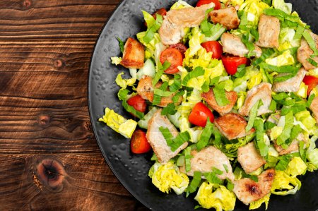 Téléchargez les photos : Salade de légumes frais, d'herbes et de viande frite dans une assiette. - en image libre de droit