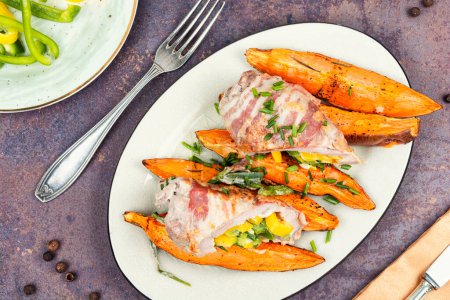 Photo for Roasted pork shoulder and sweet potatoes. Roulade with bacon and vegetables. Flat lay. - Royalty Free Image