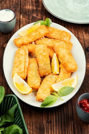 Fish fingers or nuggets, crispy fish steak on the plate. Fish sticks.