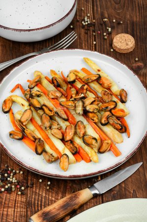 Photo for Delicious salad of roasted mussels, asparagus and carrots on a rustic background. - Royalty Free Image