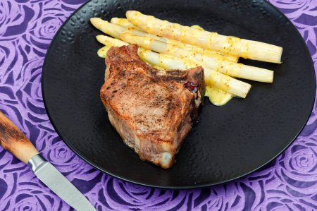 Téléchargez les photos : Steak de viande rôtie aux asperges blanches bouillies. - en image libre de droit