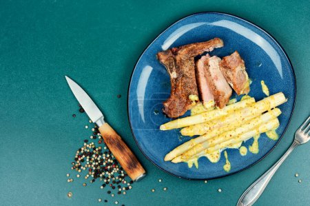Photo for Sliced roasted meat steak with boiled white asparagus. Copy space. - Royalty Free Image