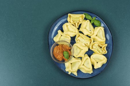 Tortelloni relleno con queso ricotta y pesto de albahaca. Copiar espacio.