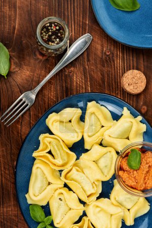 Téléchargez les photos : Tortellini, produit alimentaire italien ou boulettes remplies sur table en bois. Vue du dessus. - en image libre de droit