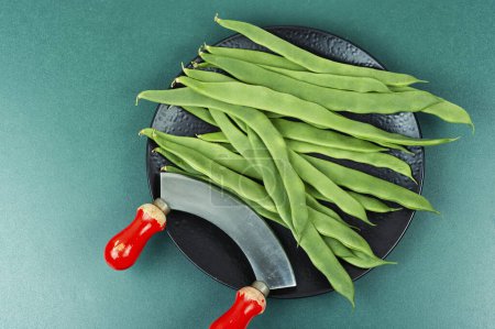 Photo for Fresh raw green beans and a grass knife. Flat lay. - Royalty Free Image