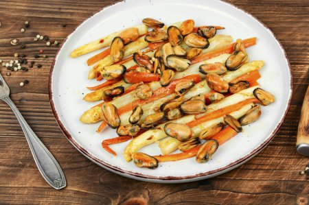 Photo for Salad with white asparagus and mussels on a modern design plate on a rustic background. - Royalty Free Image