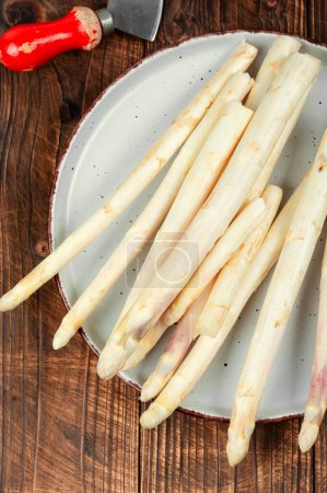 Bunch of uncooked raw white asparagus on an old rustic wooden