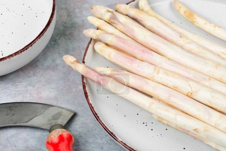 Bunch of uncooked fresh white asparagus on the kitchen table. Healthy plant food.