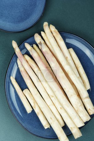 Uncooked fresh white asparagus on the kitchen table. Seasonal spring vegetables. Healthy food.