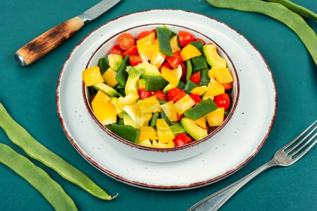 Fresh vegetable salad with bell pepper, tomato, avocado and runner beans or green bean.