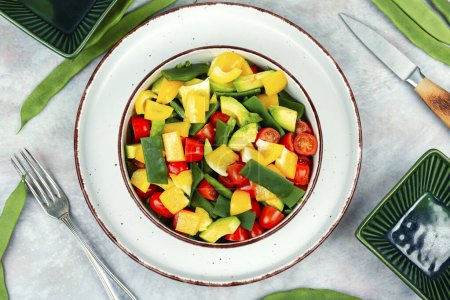 Tasty raw vegetable salad with bell pepper, tomato, avocado and runner beans or green bean. Vegetarian dish. Flat lay. Top view.
