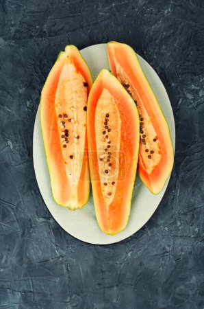Téléchargez les photos : Trancher de la papaye fraîche juteuse sur la table. Beaux fruits de papaye. Vue du dessus. - en image libre de droit