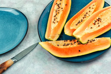 Téléchargez les photos : Tranché papaye juteuse fraîche avec couteau sur la table. Fruits sains et diététiques - en image libre de droit