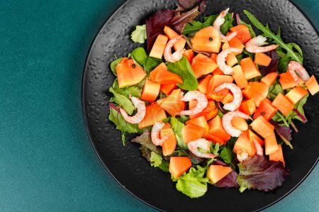 Téléchargez les photos : Salade avec papaye exotique, crevettes et légumes verts. Une nourriture saine. Aliments diététiques propres. Espace de copie. - en image libre de droit