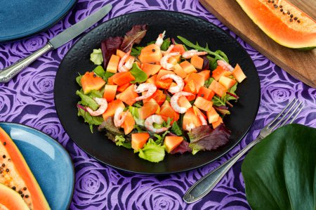 Téléchargez les photos : Salade colorée avec papaye fraîche, crevettes et vert. Salade de fruits de mer. - en image libre de droit