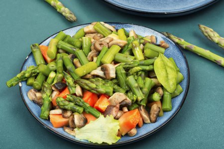 Photo for Natural green asparagus salad with roasted mushrooms on a plate. Vegetable salad. - Royalty Free Image