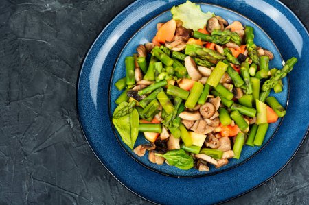 Photo for Spring salad of green asparagus and roasted mushrooms on a plate. Copy space. - Royalty Free Image