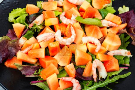 Téléchargez les photos : Salade avec papaye fraîche, crevettes et herbes. Gros plan. - en image libre de droit