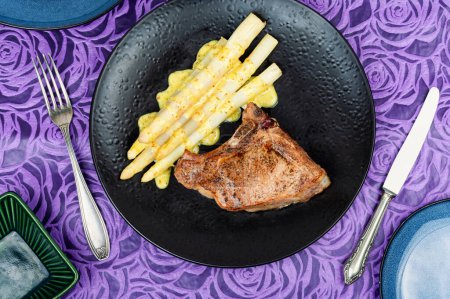 Téléchargez les photos : Steak de viande frite aux asperges blanches bouillies. Pose plate. - en image libre de droit