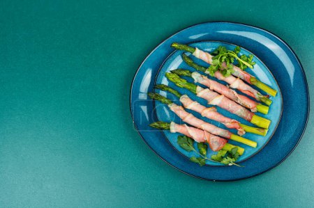 Young green asparagus baked in bacon. Free space for your text.