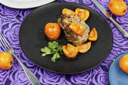 Appetizing meat baked with Mespilus germanica fruits. Delicious piece of meat roasted with medlar or loquat.