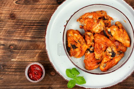 Photo for Baked chicken wings with chili sauce on rustic wooden table. Space for text. - Royalty Free Image