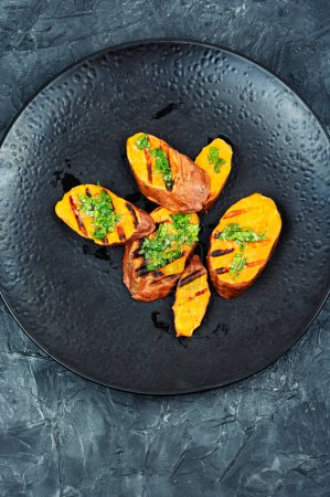 Photo for Barbecue, roasted sweet potatoes slices on the grill with herbs. - Royalty Free Image