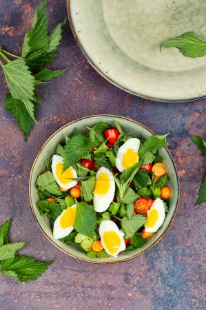 Photo for Spring green salad with nettles, tomatoes and eggs. Ukrainian food. Flat lay. - Royalty Free Image