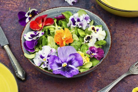 Plate with detox seasonal colorful edible flower salad.
