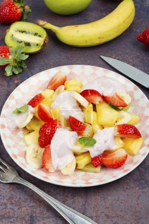 Téléchargez les photos : Aliments sains, salade de fruits vitaminés aux fraises, ananas, kiwis et yaourts. - en image libre de droit