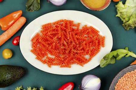 Photo for Uncooked pasta, red lentil gluten free fusilli pasta. Raw and dry macaroni. - Royalty Free Image
