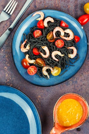 Vegetarian black bean spaghetti with prawn and tomatoes. Black pasta. Healthy food concept.
