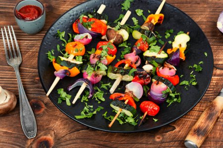 Photo for Vegan shashlik of fresh vegetables on skewers on rustic wooden table. - Royalty Free Image
