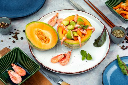 Fresh salad, fruit salad of prawn, shrimp, melon and avocado in melon.