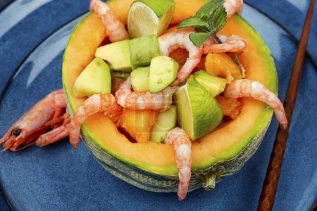 Asian salad of melon, shrimps and avocado in a half of melon. Concept of healthy eating.