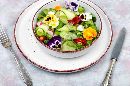 Spring vegetarian salad made from fresh vegetables and decorated with edible flowers.