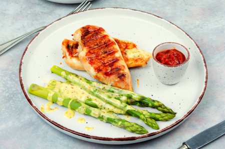 Foto de Roasted or grilled chicken breasts with green asparagus. Healthy eating concept. - Imagen libre de derechos