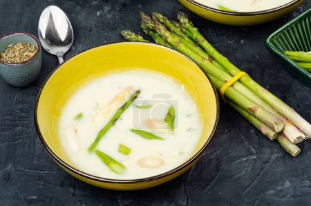 Vegan asparagus cream soup with white and green asparagus in bowl.