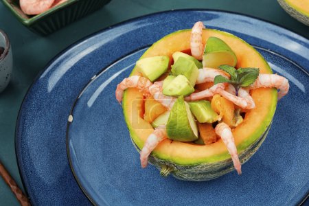 Salad, fruit salad of shrimps, melon and avocado in a half of melon.