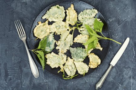 Breaded nettle or battered nettle leaves. Hot spring greens appetizer. Flat lay. Top view.