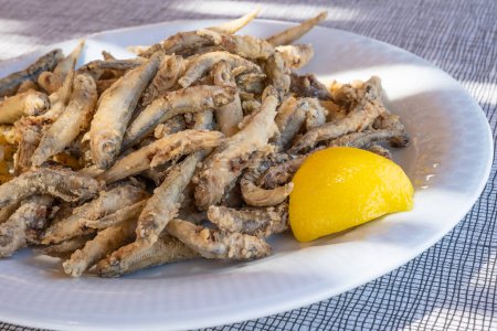 Photo for Plateful of Battered and Fried Smelts Served with a Wedge of Lemon in an Outdoor Restaurant in Symi, Greece - Royalty Free Image