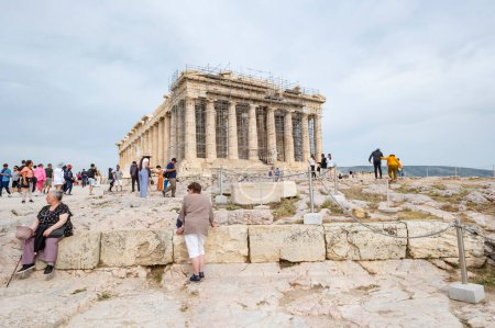 Téléchargez les photos : Athènes, Grèce - 15 mai 2023 : Des touristes dispersés sur la colline de l'Acropole autour du Parthénon en fin d'après-midi - en image libre de droit