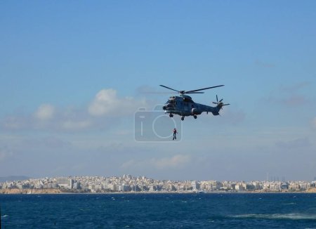 Photo for A Eurocopter AS232 Super Puma, Search and Rescue (SAR) helicopter, of the Hellenic Air Force, performing a rescue at sea, during an airshow - Royalty Free Image